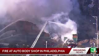 A raging fire is tearing through an auto body shop in Philadelphia [upl. by Gimble]