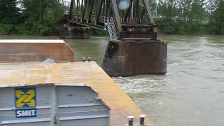 Tug boat pulling barge up Fraser river through Mission bc rail bridge [upl. by Kcirdle218]