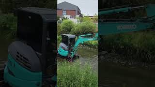 A fork crane with a large brush is scrubbing the bottom of the creek to clean out sludge [upl. by Rosenstein]